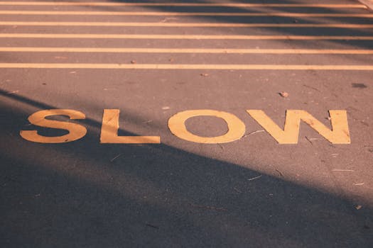 Close-up of a road with a slow sign in yellow, capturing a calm street scene in Singapore.