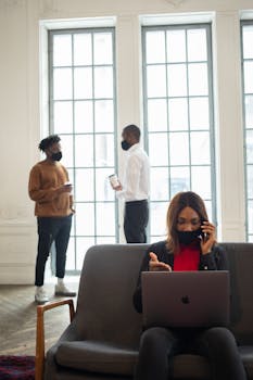 Professionals in masks working and communicating in an elegant office setting.